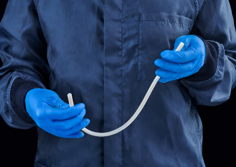 A person wearing blue gloves holding a tube

Description automatically generated